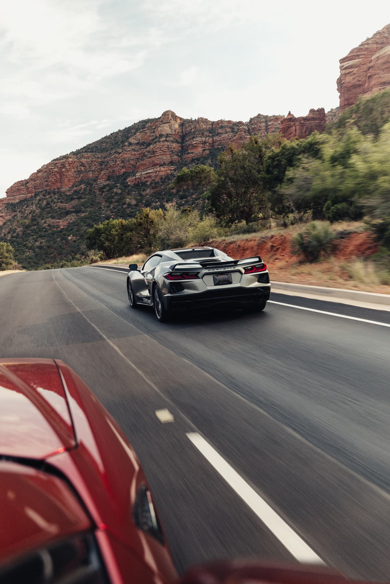 Corvette C8 climbing toward Sedona red rock